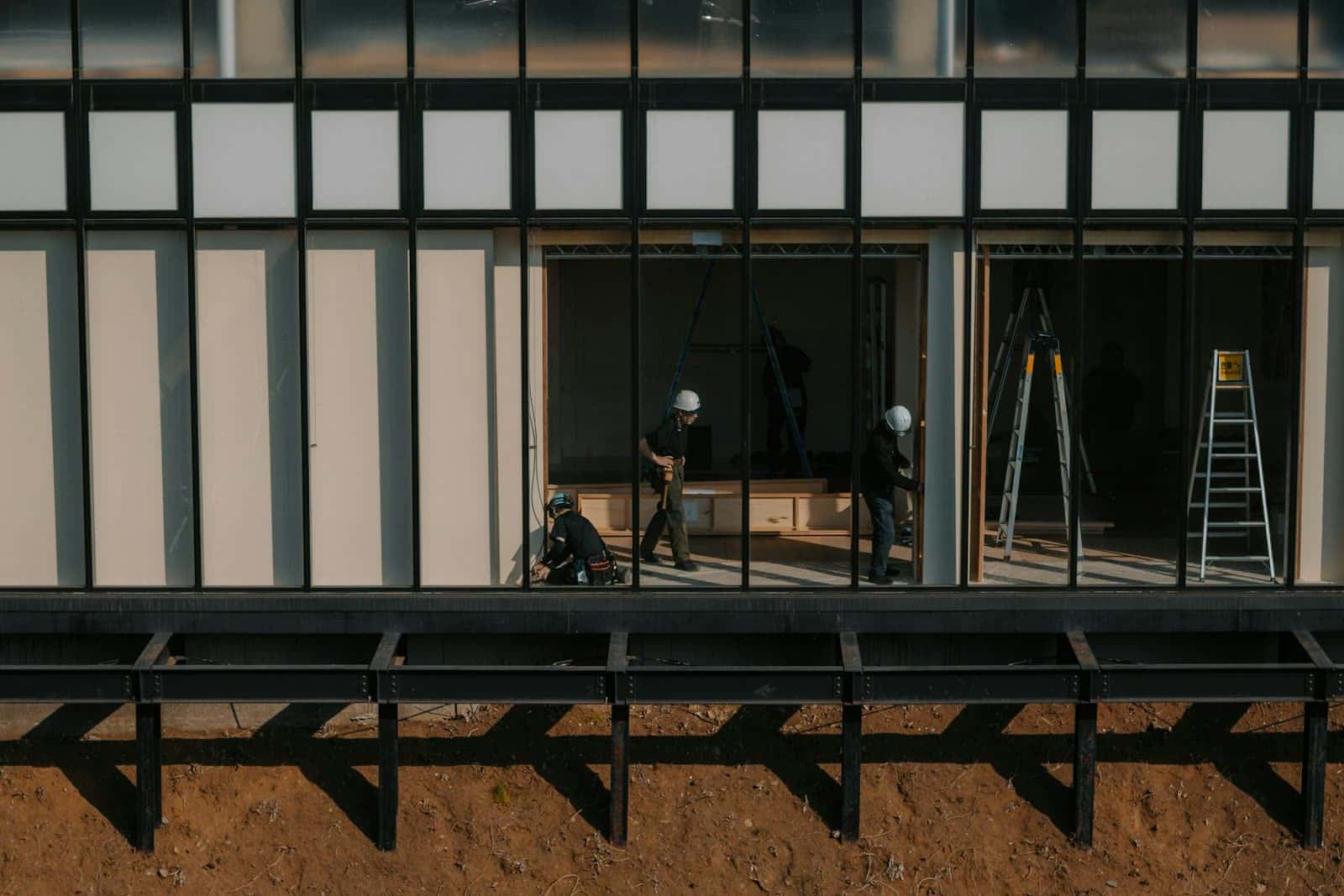 Bouwplaats met vakmensen in helmen aan een modern project
